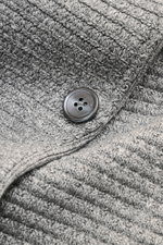 Nahaufnahme des Thom Browne Cardigan hellgrau meliert mit markantem Strickmuster, Knopf und Tricolore-Details aus Leinen, Baumwolle und Microfaser.