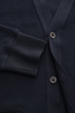 Nahaufnahme des Thom Browne Cardigan navy aus reiner Baumwolle, V-Ausschnitt, Perlmuttknöpfe, strukturierter Strick, Ärmelbündchen.
