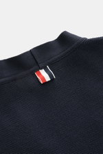 Thom Browne Cardigan navy in Nahaufnahme von oben, reine Baumwolle, fein strukturierter Strick, Tricolore-Ripsband-Detail am Kragen.