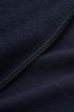 Nahaufnahme aus schräger Perspektive einer Stone Island Sweatjacke navy mit Reißverschluss, linksgestrickter Baumwoll-Microfaser-Mischung, Kapuze und Rippstrickbündchen.