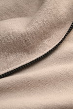 Stone Island Sweatjacke beige in Nahaufnahme, links gestrickter Strickstoff mit leicht griffiger Haptik und Reißverschluss.