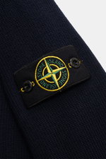 Nahaufnahme des Stone Island Cardigan navy aus reiner Baumwolle mit feinem Rippstrick-Design und Kompass-Badge am Ärmel, schräg von oben fotografiert.