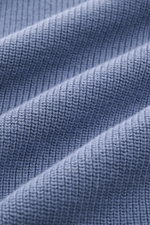 Nahaufnahme des Stone Island Cardigans rauchblau mit feinem Rippstrick-Design aus reiner Baumwolle und mittelfeinem Strickbild.