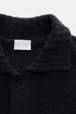 Nahaufnahme des Kragens und der Knopfleiste des navyfarbenen 04651/ A trip in a bag Cardigan 'Chunky Overshirt' aus voluminösem Strick mit weichem Griff.
