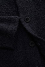 Nahaufnahme des navyfarbenen 04651/ A trip in a bag Cardigan 'Chunky Overshirt' mit voluminösem Strickbild, Knöpfen und Brusttasche, aus Schurwolle-Mix.