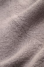 Nahaufnahme des mittelfeinen Strickbilds und der weichen Baumwolle des Fioroni Cardigan grau, fotografiert aus schräger Perspektive.