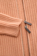 Nahaufnahme der apricotfarbenen Iris von Arnim Cashmere Strickjacke 'Avenor' mit voluminösem Patentstrick und zwei-Wege-Reißverschluss, von oben fotografiert.