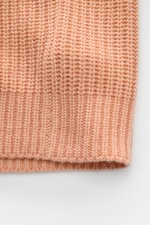 Nahaufnahme der voluminösen, apricotfarbenen Iris von Arnim Cashmere Strickjacke 'Avenor' mit weichem Griff und Patentstrickmuster.