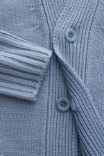 Nahaufnahme des 04651/ A trip in a bag Cardigan 'Foggy' rauchblau aus reiner Wolle mit Knöpfen, Rippbündchen und mittlerem Strickbild.