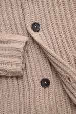 Close-up, top-down view of the von Braun Cashmere cardigan beige showing the chunky brioche stitch knit, shawl collar, soft Mongolian cashmere, slim fit, and four dark buttons. How about a less chunky knit? This cardigan in brioche stitch from the VON BRA