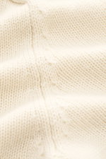 Nahaufnahme des von Braun Cashmere Cardigan offwhite mit mittelfeinem Strickbild aus reinem, mongolischem Cashmere, weicher Griff sichtbar.