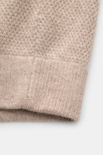 Nahaufnahme des Ärmels der von Braun Cashmere Strickjacke beige meliert, zeigt weichen, edlen Strukturstrick mit Rippbündchen.