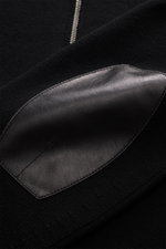 Nahaufnahme der Tom Ford Strickjacke schwarz aus reiner Schurwolle, zeigt Lederdetails am Zwei-Wege-Reißverschluss und breite Rippbündchen.