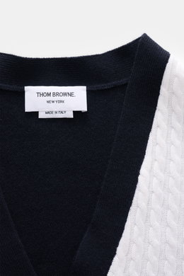 Nahaufnahme von Thom Browne Cardigan weiß/schwarz, fotografiert von oben, mit klassischem Zopfstrick, weichem Griff und vier Knöpfen.