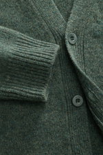 Nahaufnahme des A.P.C. Cardigans 'Kevin' graugrün meliert, von schräg oben fotografiert, zeigt reine Wolle, Knöpfe, Rippbündchen.