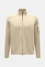 Frontansicht der sandfarbenen C.P. Company Strickjacke mit puristischem Design, Waffelstrick, Slim Fit, Zwei-Wege-Reißverschluss und Oberarm-Zipper-Tasche.
