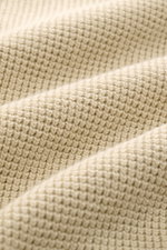 Nahaufnahme der sandfarbenen C.P. Company Strickjacke mit puristischem Design, Waffelstrick-Optik und mittelfeinem Strickbild.