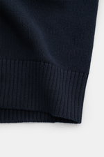 Nahaufnahme der Stone Island Strickjacke 'Ghost Piece' navy mit mittelfeinem Strickbild, weichem Griff und flexiblem Rippbündchen, Detail von unten fotografiert.