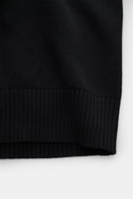 Stone Island Strickjacke 'Ghost Piece' schwarz, Detailaufnahme von unten, weicher Baumwoll-Cashmere-Mix, mittelfeines Strickbild, Rippbündchen sichtbar.
