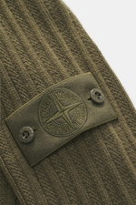 Nahaufnahme der Stone Island Strickjacke 'Ghost' oliv, Perspektive seitlich auf das tonale Kompass-Badge am Oberarm aus Schurwoll-Cashmere-Mix.