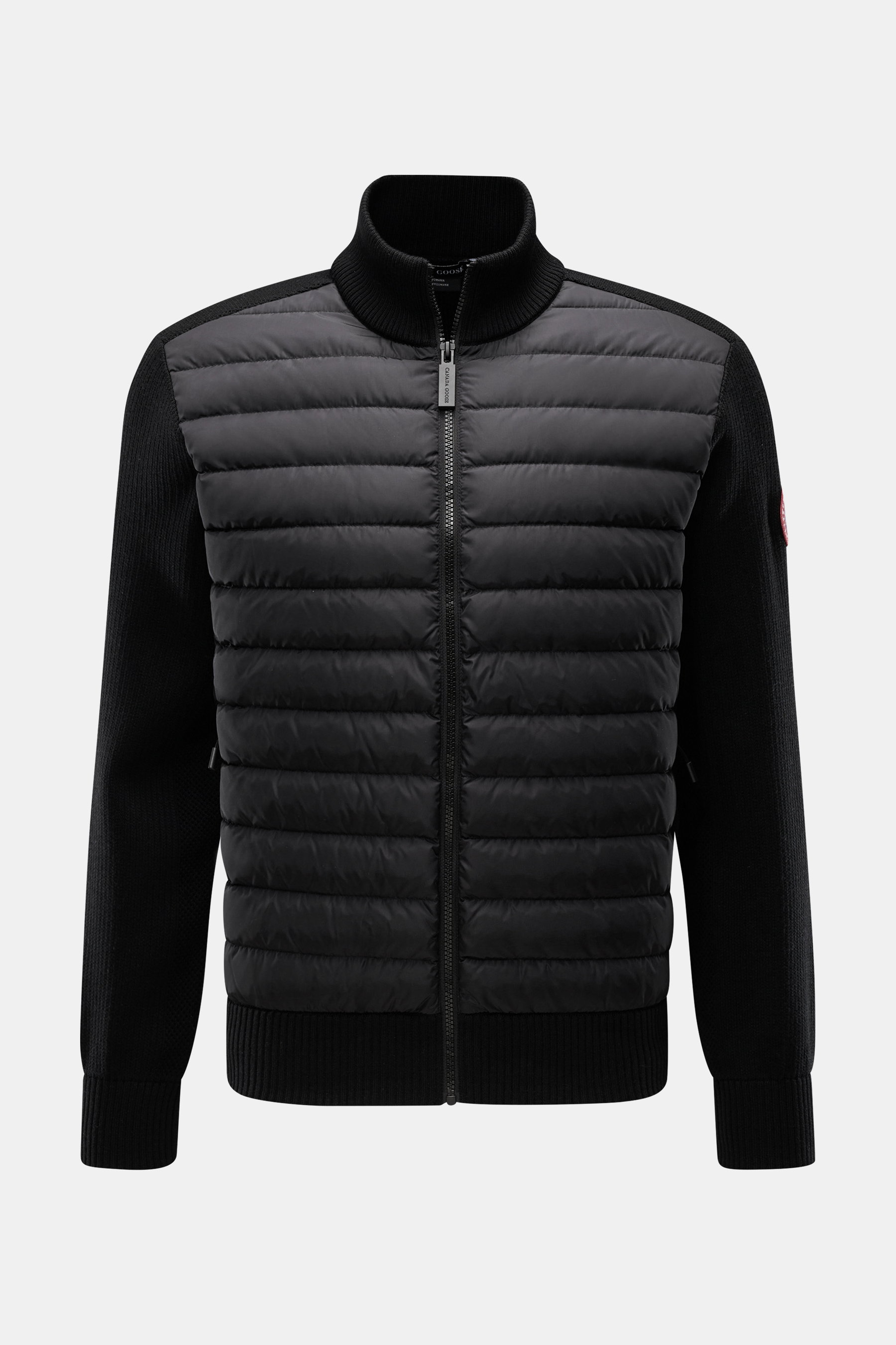 alt-Tag: Vorderansicht der Canada Goose Strickjacke 'Hybridge Knit' schwarz mit Daunenfüllung vorne, Wollstrickärmeln, Stehkragen und Zipper-Taschen.