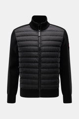alt-Tag: Vorderansicht der Canada Goose Strickjacke 'Hybridge Knit' schwarz mit Daunenfüllung vorne, Wollstrickärmeln, Stehkragen und Zipper-Taschen.