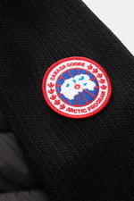 Nahaufnahme der Canada Goose Strickjacke 'Hybridge Knit' schwarz, Detail des Wollstricks mit kontrastierendem Weblabel, Front mit Daunenfüllung.
