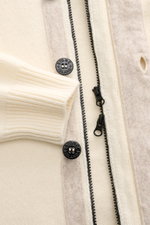 Stone Island Cardigan 'Lambswool' cream close-up from above showing wool blend knitwear with purl-knit sections, embossed buttons, felt details, robust two-way zip, and ribbed bands.