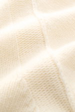 Close-up front view of the Stone Island Cardigan 'Lambswool' cream showing warm wool blend knitwear with distinctive purl-knit sections, embossed buttons, felt details, and the compass badge on the upper sleeve, designed for cool days with a slim fit, sta