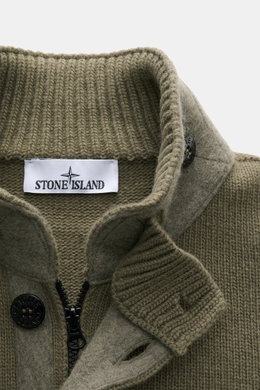 Close-up front view of Stone Island Cardigan 'Lambswool' olive showing the standing collar with ribbed knit texture, embossed buttons, robust two-way zip, and felt details. A stylish essential for cool days: this casual cardigan by STONE ISLAND in a warm 