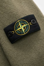 Close-up front view of Stone Island Cardigan 'Lambswool' olive showing purl-knit wool, felt details, embossed buttons, and compass badge on sleeve. 

Description: A stylish essential for cool days: this casual cardigan by STONE ISLAND in a warm wool blend
