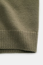 Close-up front view of Stone Island Cardigan 'Lambswool' olive showing medium-fine wool knit, ribbed elastic bands, and purl-knit sections.