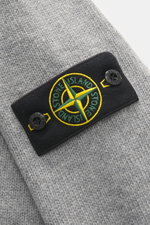 Stone Island Strickjacke 'Lambswool' grau meliert, Nahaufnahme der Front mit markantem Kompass-Badge, feinem Wollmix und Knöpfen.
