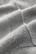Stone Island Strickjacke 'Lambswool' grau meliert Nahaufnahme des weichen Wollmix mit mittelfeinem Linksstrick und Filz-Details, Detailansicht.