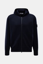 Stone Island Strickjacke 'Stretchwool' schwarz, frontale Nahaufnahme mit Kapuze, Raglan-Ärmeln, Reißverschluss und Kompass-Badge am Oberarm.