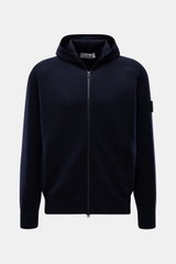 Stone Island Strickjacke 'Stretchwool' schwarz, frontale Nahaufnahme mit Kapuze, Raglan-Ärmeln, Reißverschluss und Kompass-Badge am Oberarm.