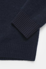 Nahaufnahme des Stone Island Cardigan navy von oben, weicher Griff, mittelfeines Strickbild, Rippbündchen, Kompass-Badge, Mix aus Alpaka, Schurwolle, Microfaser.