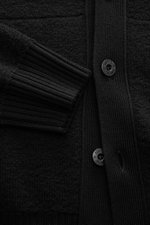 Close-up front view of the Stone Island Cardigan black showing pure virgin wool texture, four-button placket, ribbed cuffs, and welt pocket.

Description: <p>Comfortable essential: The cardigan from STONE ISLAND made of pure virgin wool impresses with war