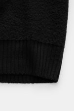 Close-up shot of the ribbed cuff and textured knit fabric of the Stone Island Cardigan black, made of pure virgin wool with soft touch, regular fit, four-button placket, welt pockets, compass badge on the upper arm, and comfortable ribbed cuffs. Comfortab