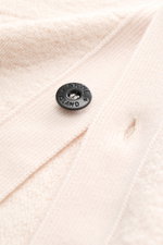 Close-up front view of Stone Island Cardigan cream showing pure virgin wool texture, four-button placket, and soft ribbed cuffs.