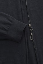 Nahaufnahme der Emporio Armani Strickjacke navy mit verdecktem Zwei-Wege-Reißverschluss, geripptem Stehkragen, Slim Fit, Rippbündchen, aus reiner Schurwolle mit feinem Strickbild und weichem Griff, tonales Logo-Stitching sichtbar.