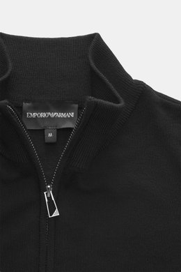 Nahaufnahme aus leicht schräger Draufsicht der Emporio Armani Strickjacke schwarz mit geripptem Stehkragen, verdecktem Zwei-Wege-Reißverschluss, Slim Fit, feinem Strickbild, weichem Griff, reiner Schurwolle, tonalem Logo-Stitching und komfortablen Rippbün