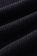 Close-up front view of Belstaff Cardigan 'Commander' black, showing pure cotton fabric with slightly textured quality, fine rib stitch pattern, flat knit details, and ribbed stand-up collar. Features slim fit, concealed metal zipper, BELSTAFF woven label 