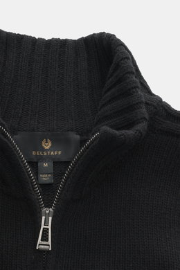 Close-up front view of Belstaff Cardigan 'Watch' black showcasing pure wool fabric with a soft touch, coarse knit pattern, rib knit elements, slim fit, stand-up collar, two-way zipper, BELSTAFF woven label on the chest, and flexible ribbed cuffs.