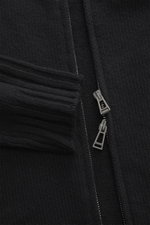 Close-up front view of Belstaff Cardigan 'Watch' black showing pure wool coarse knit pattern, soft touch, rib knit elements, slim fit, stand-up collar, two-way zipper with BELSTAFF woven label on the chest, and flexible ribbed cuffs.