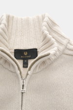 Close-up front view of the Belstaff Cardigan 'Watch' cream, showing pure wool coarse knit pattern, soft touch, rib knit elements, ribbed cuffs, slim fit, stand-up collar, two-way zipper, and BELSTAFF woven label on the chest.