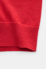 Nahaufnahme des Saums eines roten Malo Cashmere Cardigans mit feinem Strickbild und komfortablen Rippbündchen, fotografiert von vorne unten.