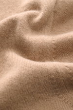 Nahaufnahme des weichen Strickbilds vom Malo Cashmere Cardigan hellbraun, fotografiert aus schräger Perspektive, mit feinem Slim Fit, V-Ausschnitt, fünf Knöpfen und komfortablen Rippbündchen.