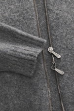 Nahaufnahme der Drumohr Strickjacke dunkelgrau meliert von schräg oben, reine Lammwolle, weicher Griff, mittelfeines Strickbild, Slim Fit, Zwei-Wege-Reißverschluss, anliegender Stehkragen, komfortable Rippbündchen.