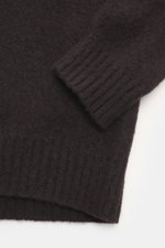 Nahaufnahme der Ärmelpartie der Drumohr Strickjacke dunkelbraun, reine Lammwolle, weicher Griff, mittelfeines Strickbild, Slim Fit, Stehkragen, Rippbündchen, Zwei-Wege-Reißverschluss, Ansicht von oben.